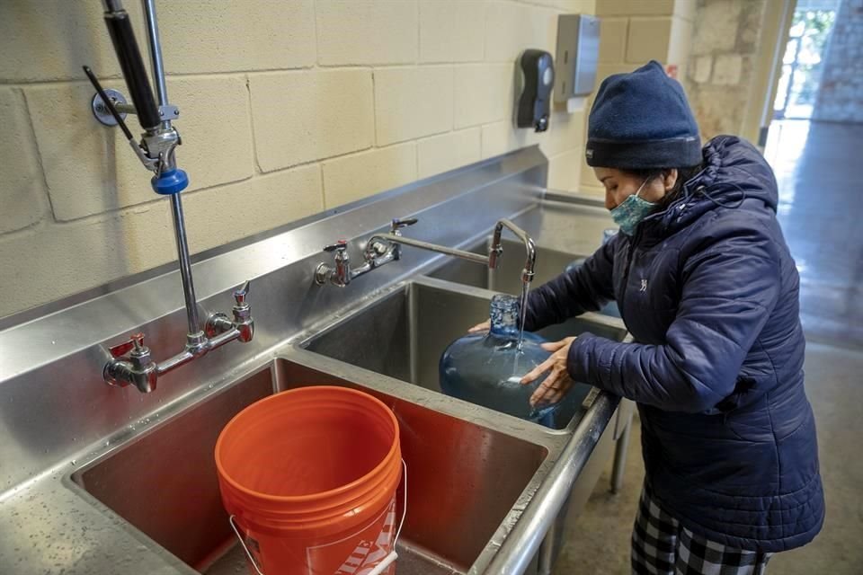 Una mujer en Austin, texas, llena un contenedor de agua en medio de la crisis en EU.