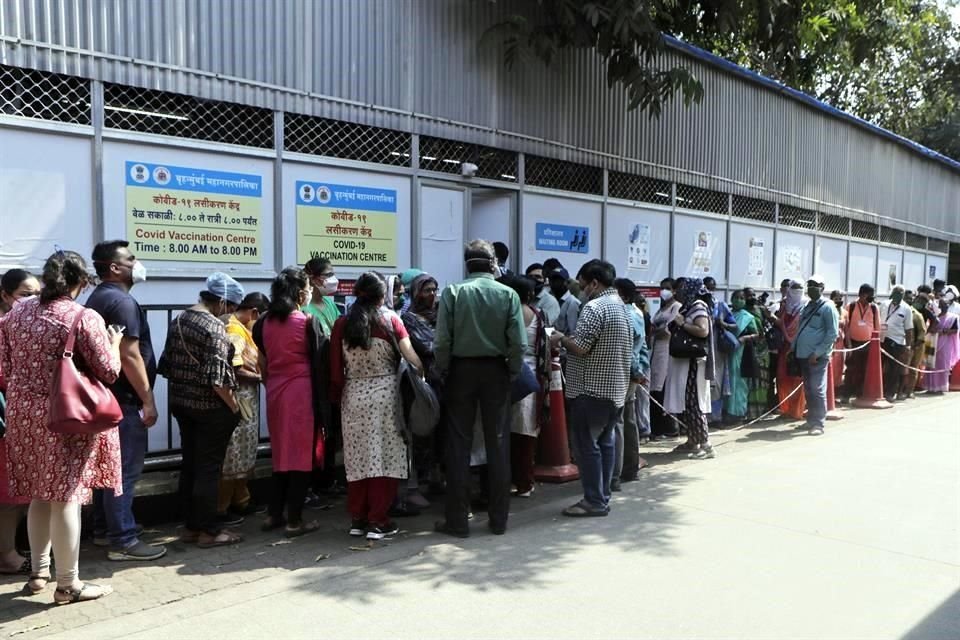 Personas en India esperan en una fila para recibir la vacuna contra el coronavirus.