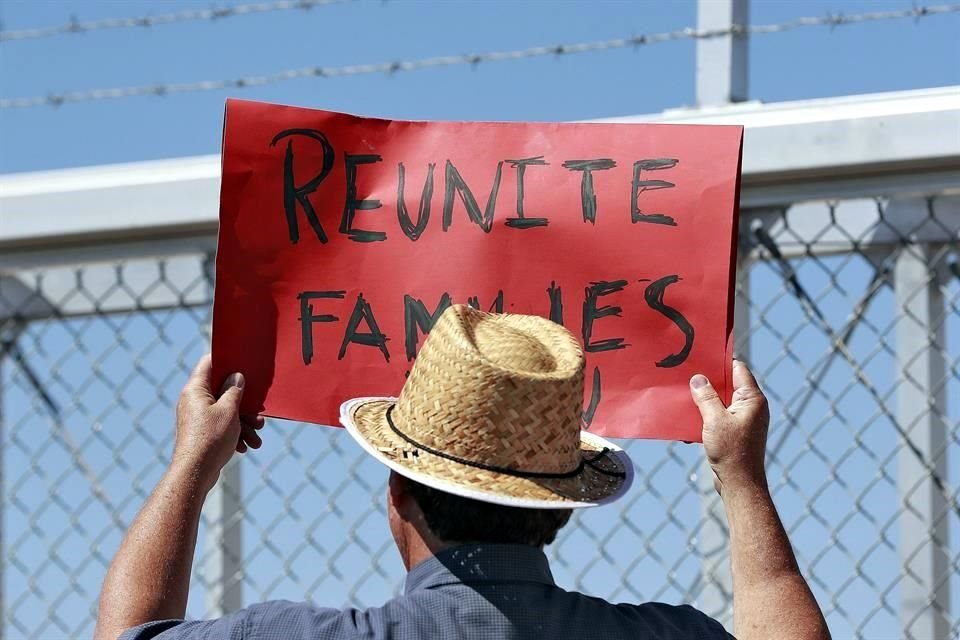 Un manifestante pide la reunificación de familias migrantes en una instalación de Texas usada como albergue.