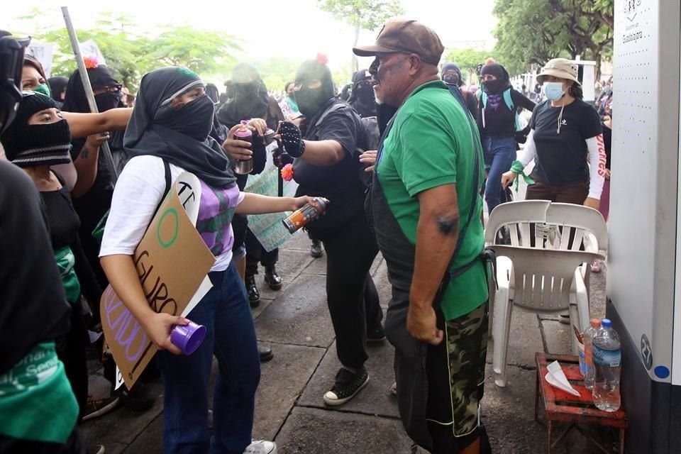 Marchan feministas por la legalización del aborto, y echan aerosol a uno de los boletos que trato de impedir que rayaran su puesto.