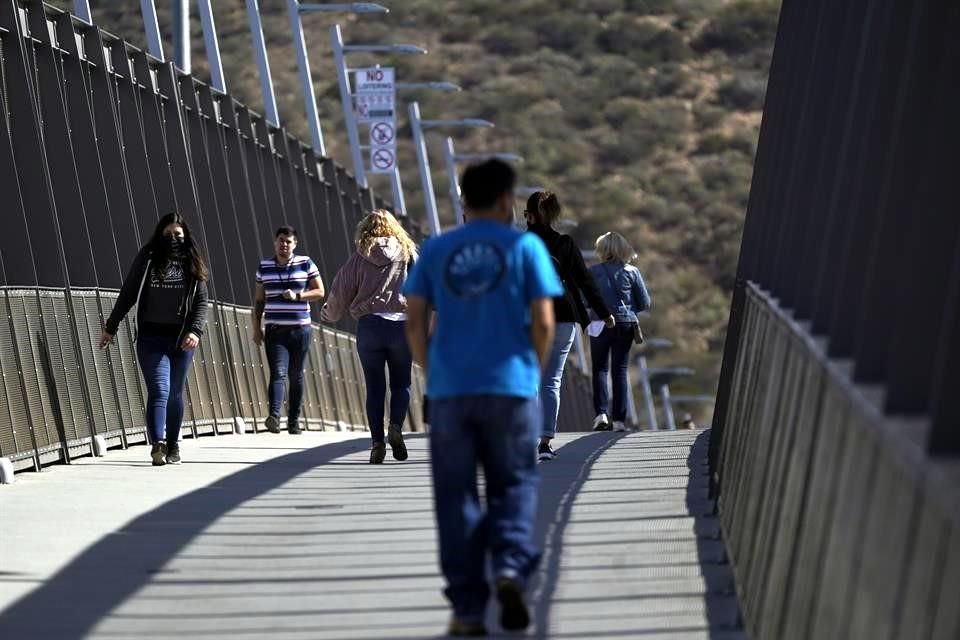 Personas caminan sobre el puente de entrada de San Ysidro, que conecta Tijuana con Estados Unidos.