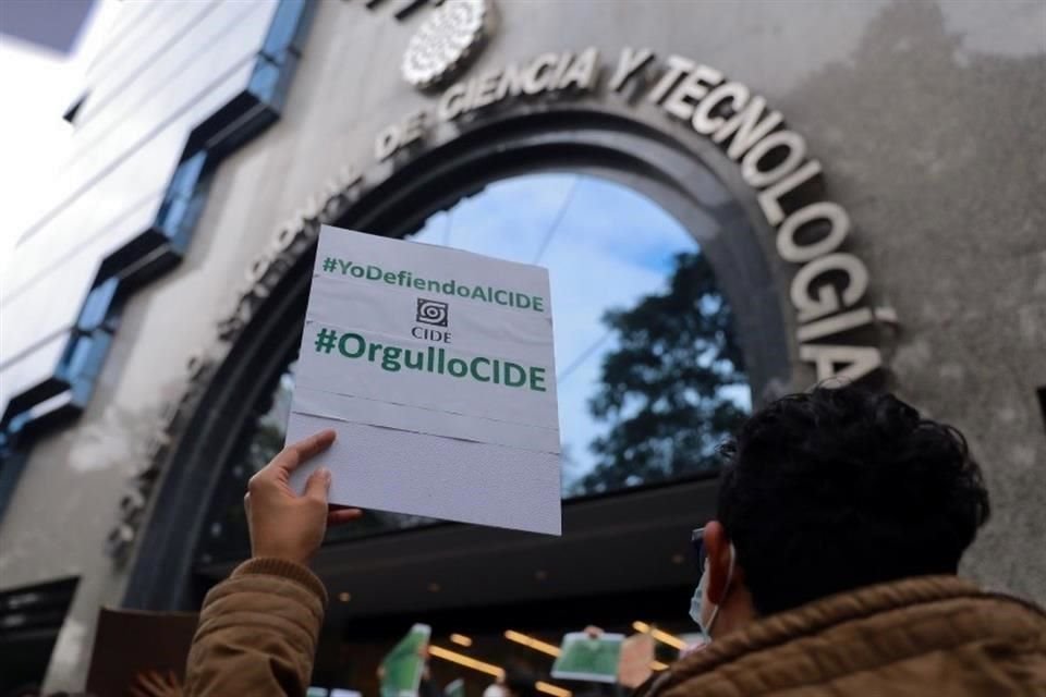 Un estudiante sostiene un cartel con la leyenda 'Yo defiendo al CIDE' frente a la sede del Conacyt.