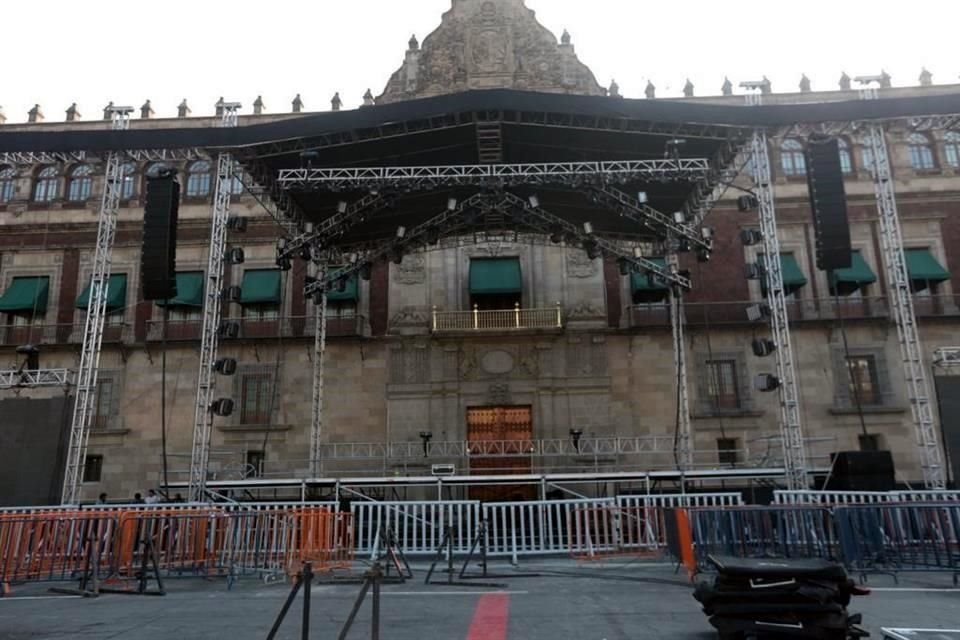 Trabajadores instalan un gran escenario techado, habilitado con torres de luz y sonido.