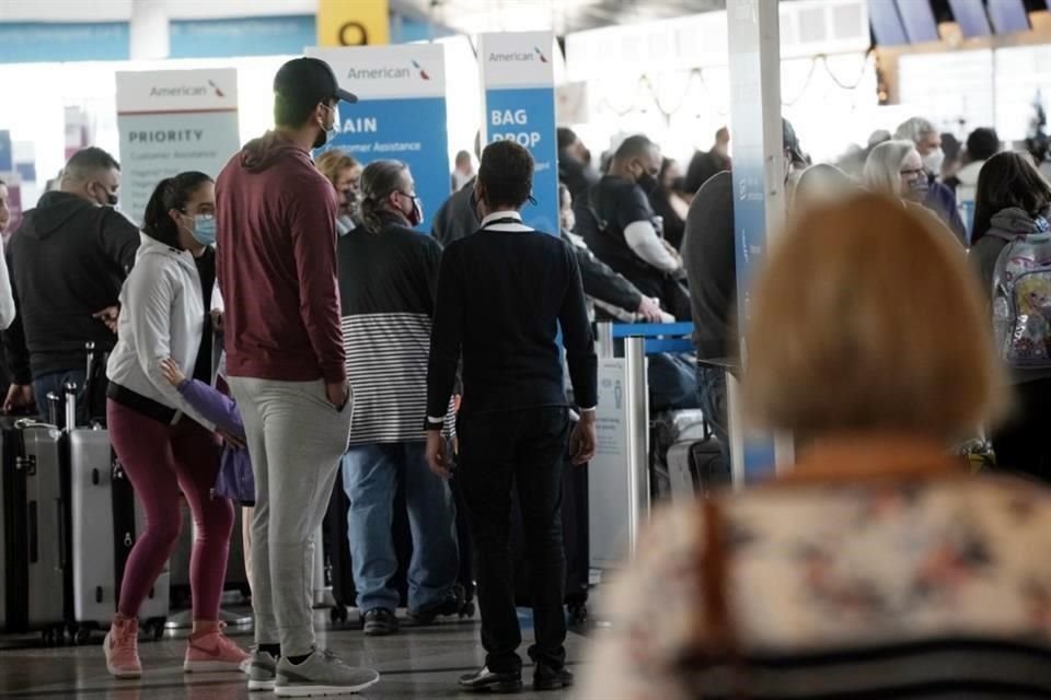 Viajeros en el aeropuerto de Denver hacen fila para registrarse este domingo.