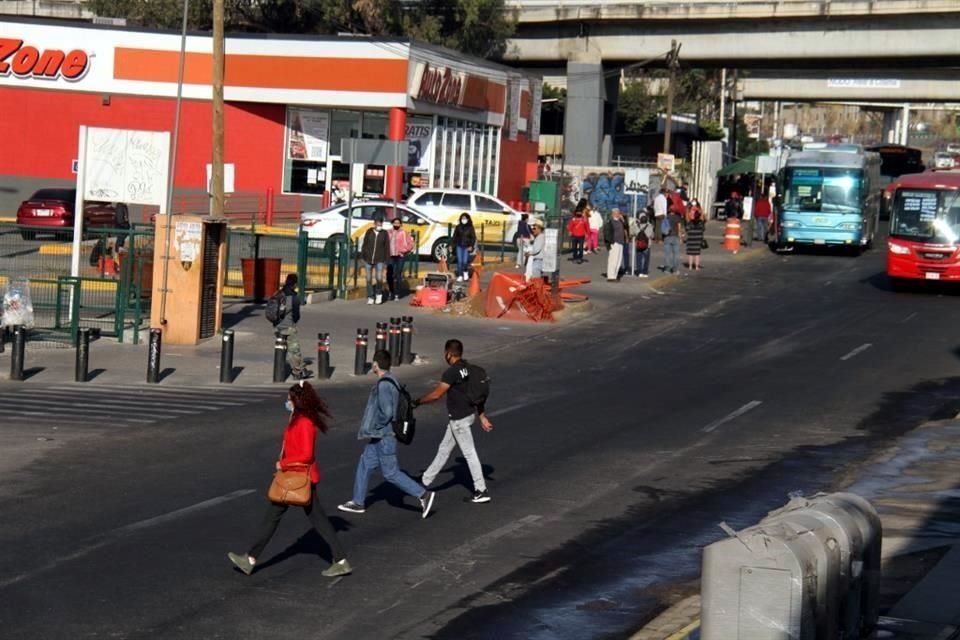 Los peatones cruzan la lateral en medio del paso de camiones y vehículos de carga.