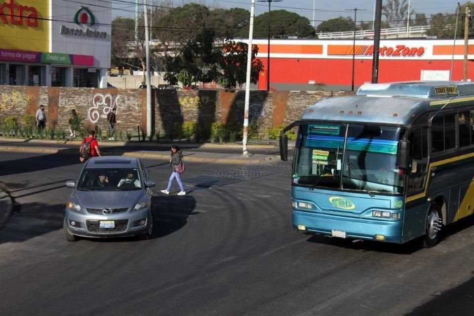 Un peatón libra el paso en Periférico y Colón, en medio de dos vehículos que transitan en el punto.