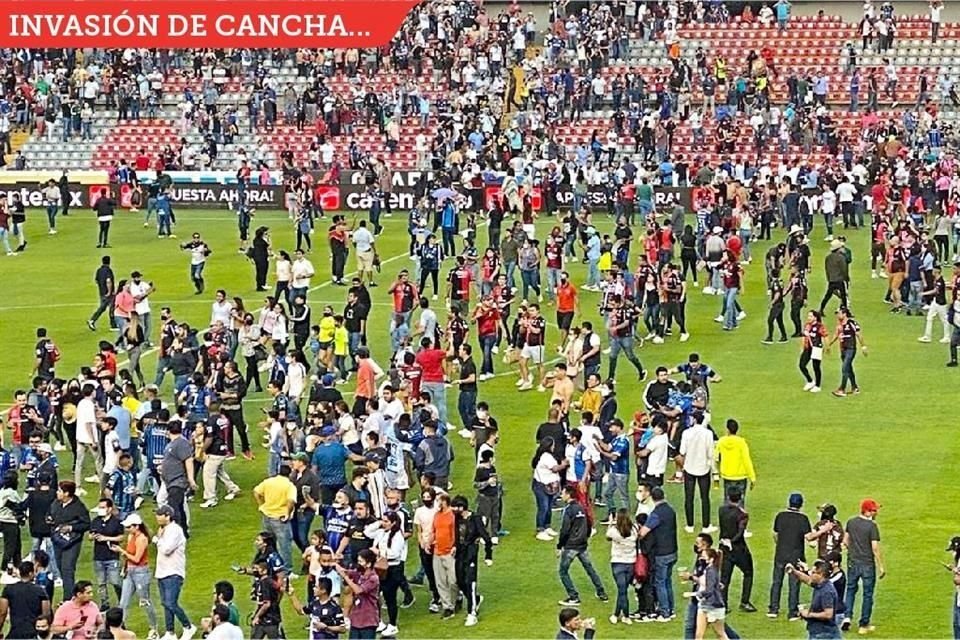 Aficionados corrieron al campo de juego para protegerse.