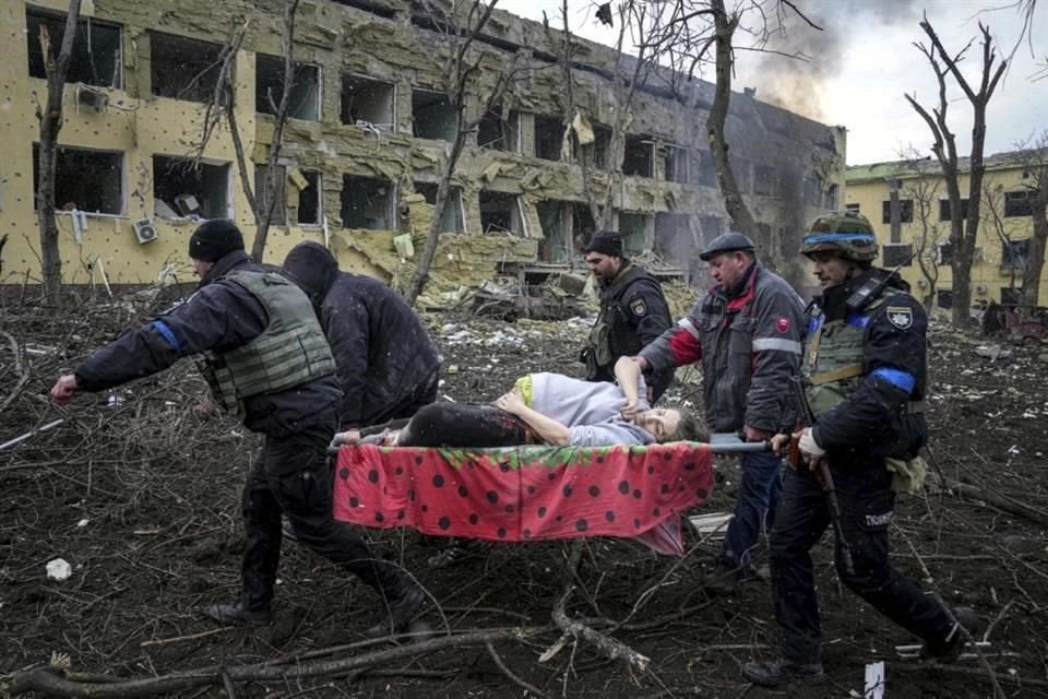 Rescatistas transportan a una mujer embarazada del hospitla que fue bombardeado.