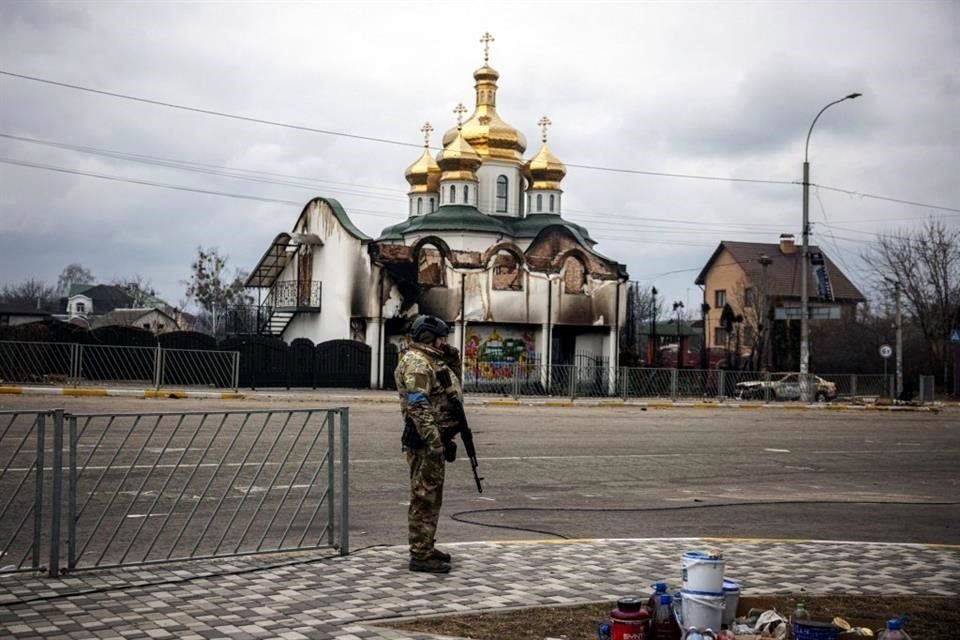 Un guardia ucraniano vigila las calles de la ciudad de Irpin, cerca de Kiev, enfrente de un edificio dañado por los ataques rusos.