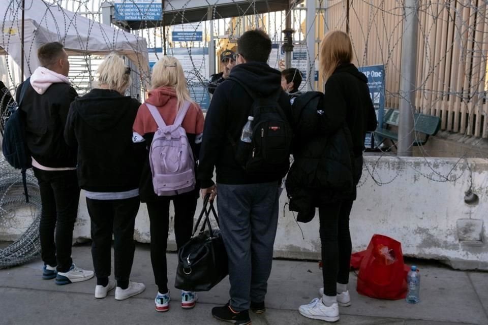 Un grupo de ucranianos habla con un oficial de CBP en el paso fronterizo de San Ysidro, en Tijuana.