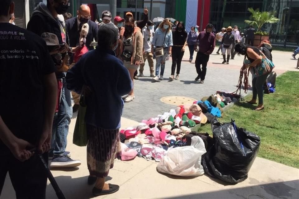 Una mujer ofrecía a los visitantes gorras de Morena.