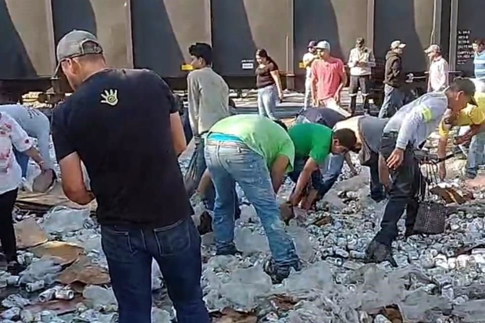 Personas llevándose la cerveza del tráiler que se volcó por intentar ganarle el paso al tren.