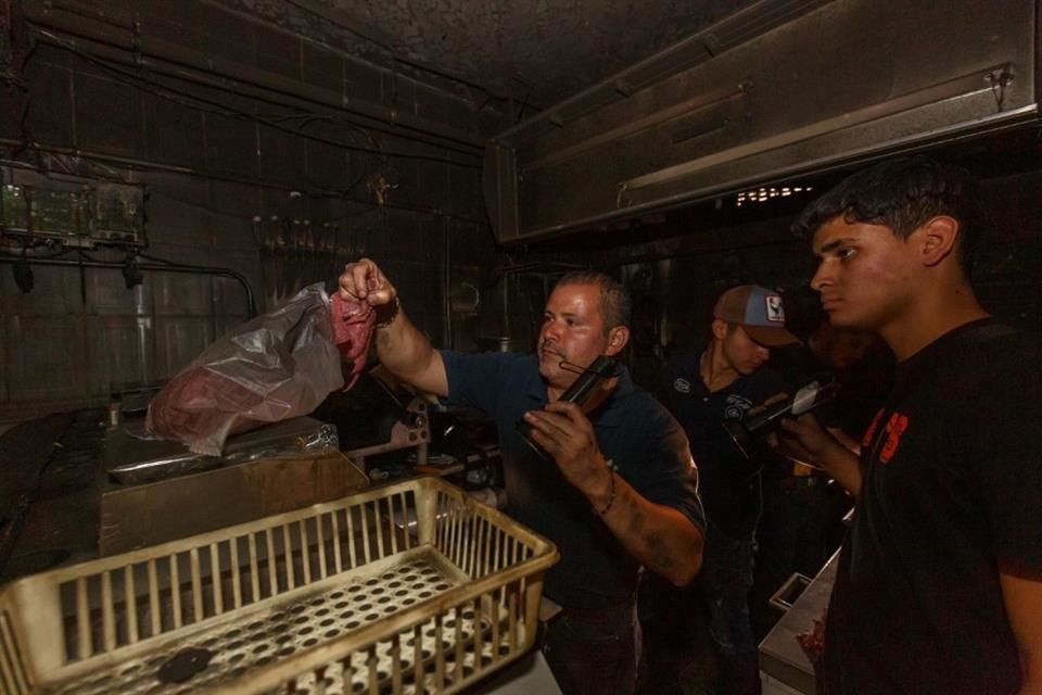 Carlos Pérez y sus ayudantes cortan carne para entregar un pedido, pues, tras el incendio del Mercado San Juan de Dios, sus clientes se solidarizaron con su negocio.