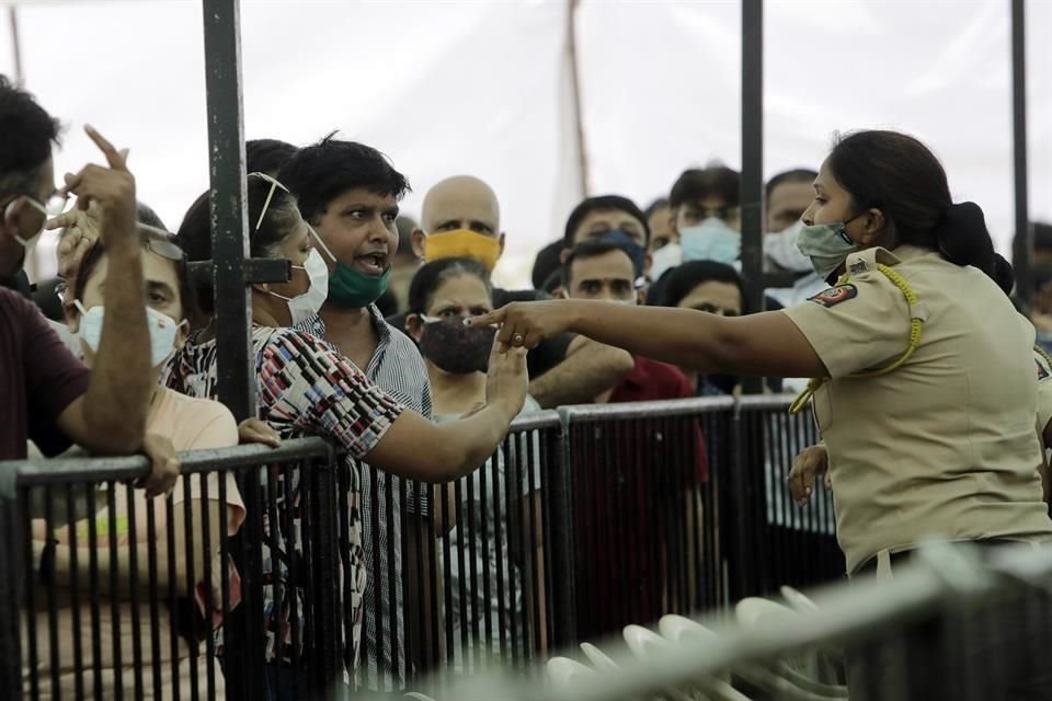 Una mujer policía discute con personas formadas para vacunarse contra Covid-19.