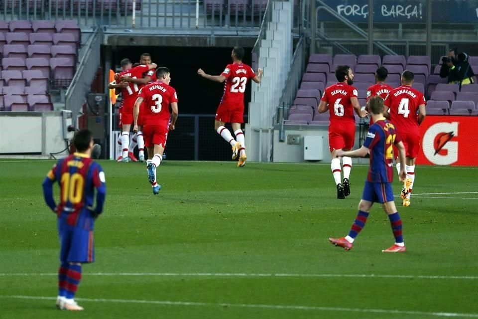 Mientras los elementos del Granada festejan, Lionel Messi lamenta el gol en contra.