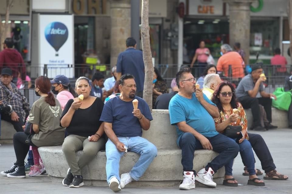 Personas en el Centro de Guadalajara se refrescan con un helado.