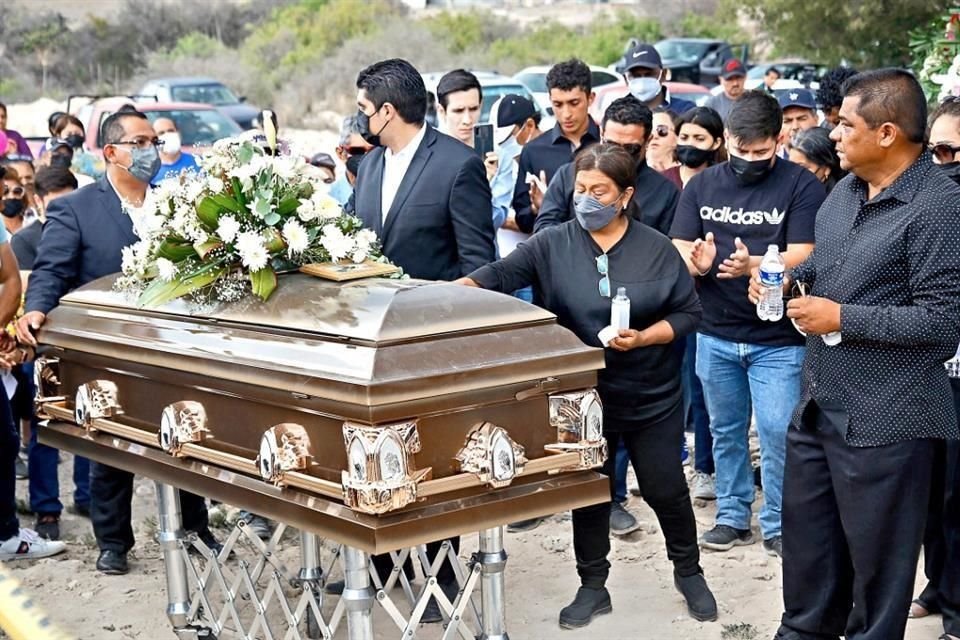 Los padres de Debanhi, Susana Bazaldúa (tocando el féretro) y Mario Escobar (derecha), despidieron ayer a su hija acompañados de familiares y amigos, en Galeana, Nuevo León.