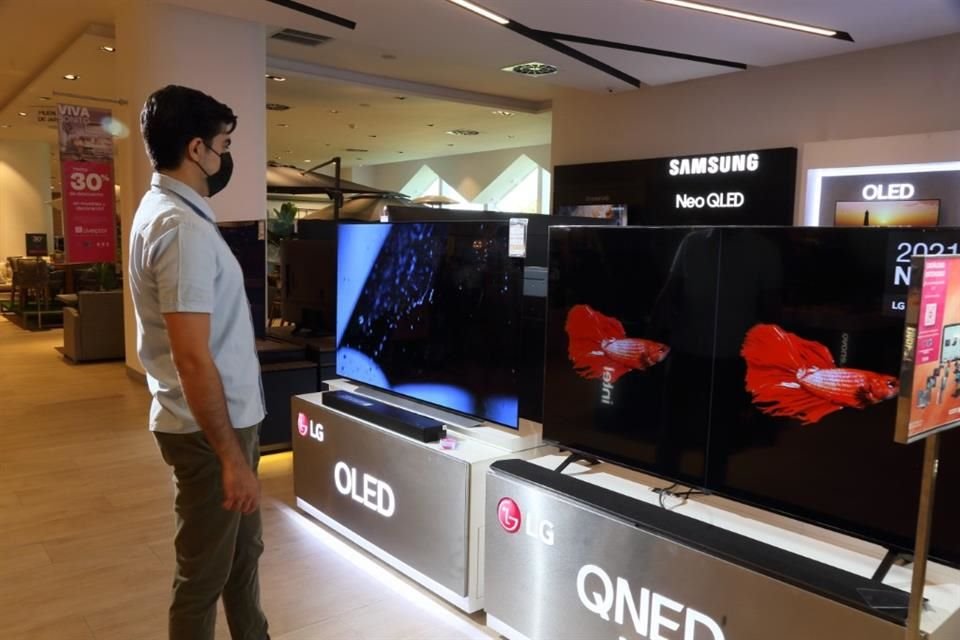 Consumidor observa la variedad de televisores en una tienda departamental.