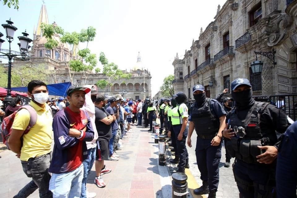 Los manifestantes se mantienen a la espera de que se libere a las personas detenidas por policías antimotines.