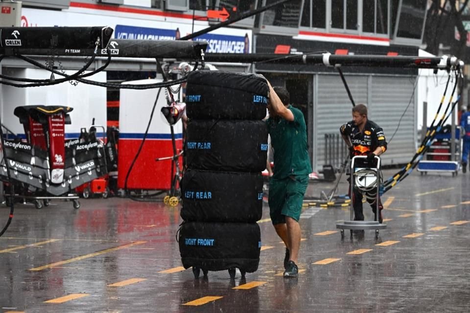 Técnicos transportan las llantas bajo la lluvia en Mónaco.