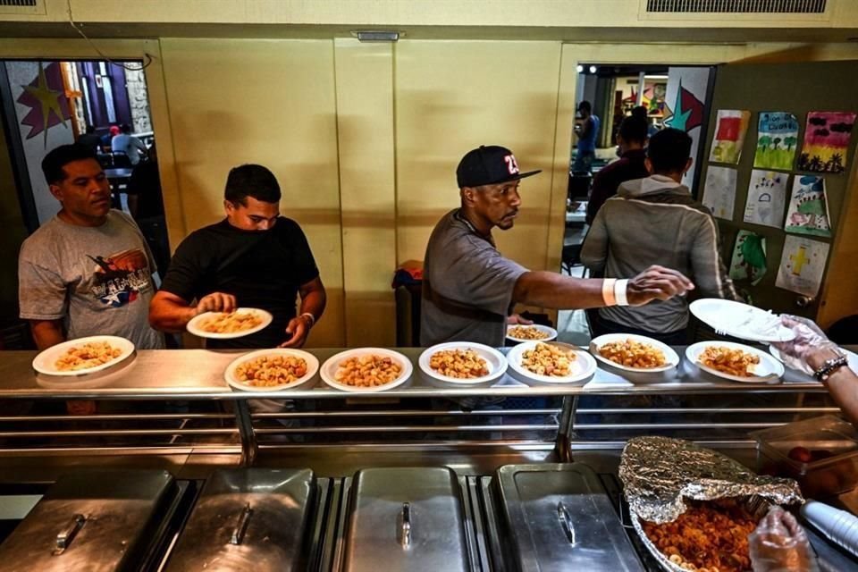 Migrantes hacen fila en un refugio en San Antonio, Texas, para recibir comida.