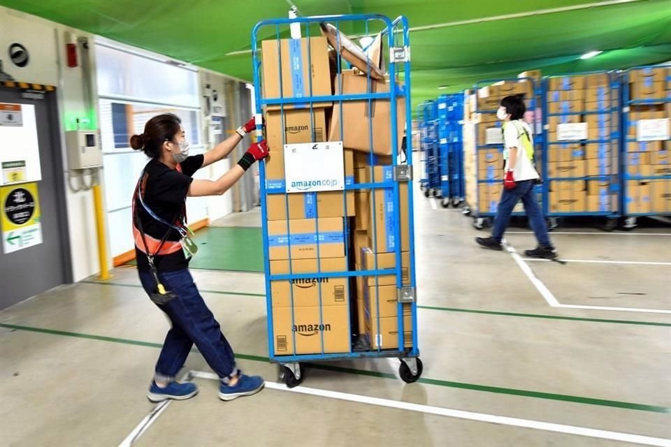 Un trabajador de Amazon en Amagasaki, Japón, transporta paquetes en un carrito.