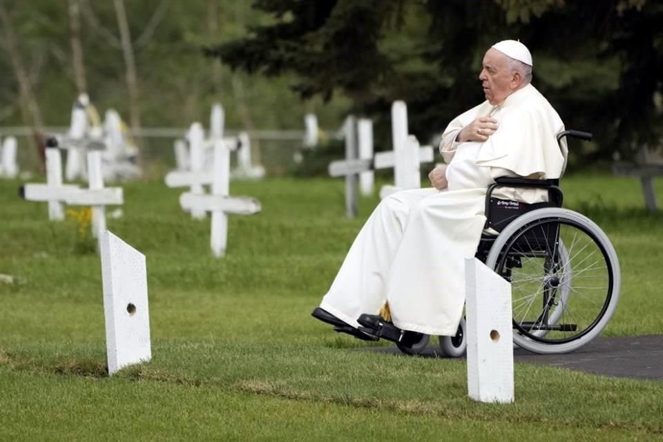 El Papa Francisco reza en una tumba en el cementerio Ermineskin Cree Nation en Maskwacis, Alberta, durante su visita papal a Canadá.