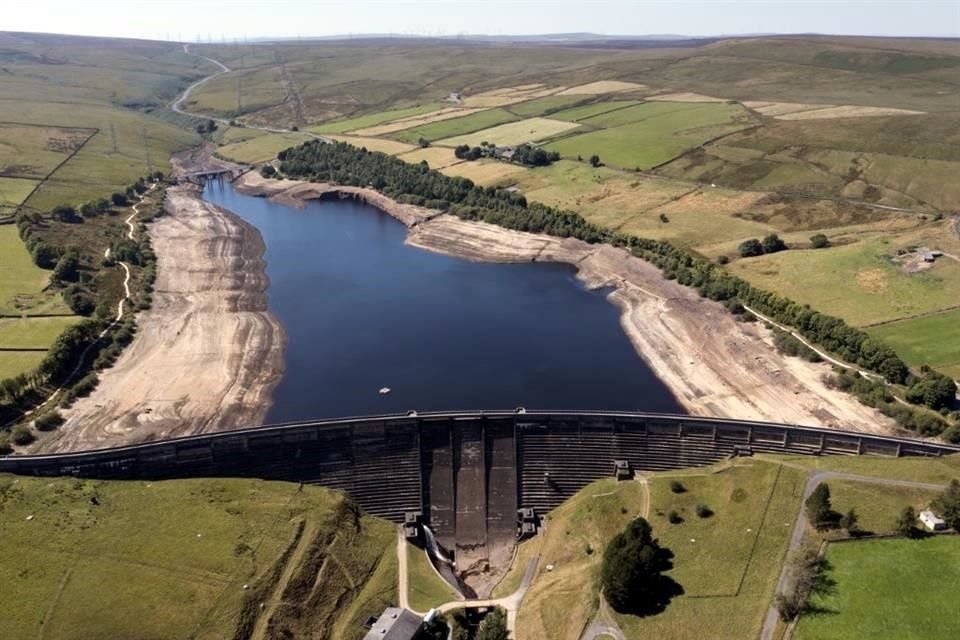 El muro de una presa y las áreas expuestas por los bajos niveles de agua se ven en el embalse de Baitings en Yorkshire en Ripponden, Inglaterra.