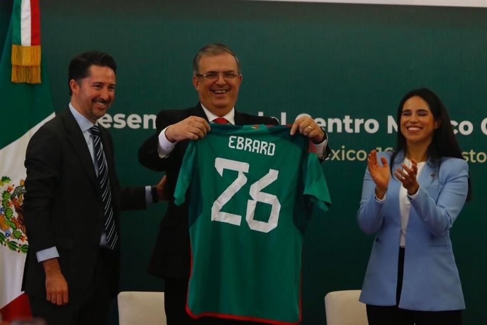 El Canciller Marcelo Ebrard recibe una playera de la Selección Mexicana con el número 26, año en el que México albergará el próximo Mundial.