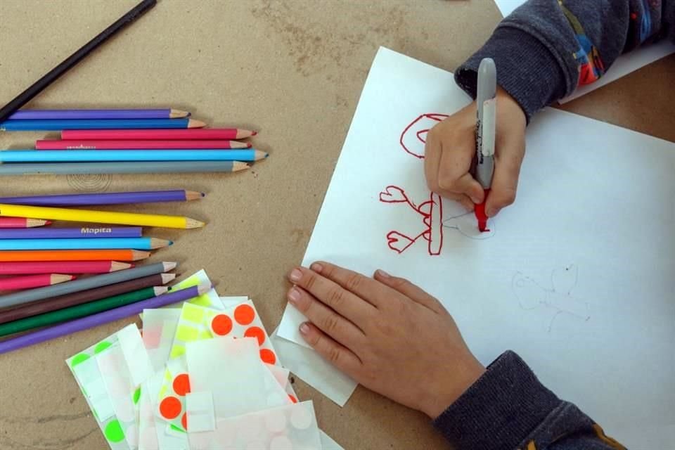 Niños dibujando para desarrollar la motricidad fina.