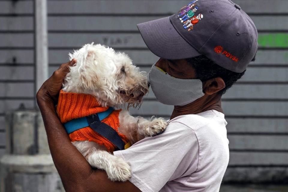 Un hombre sostiene a su perro durante una protesta contra el abuso animal en Caracas, Venezuela.