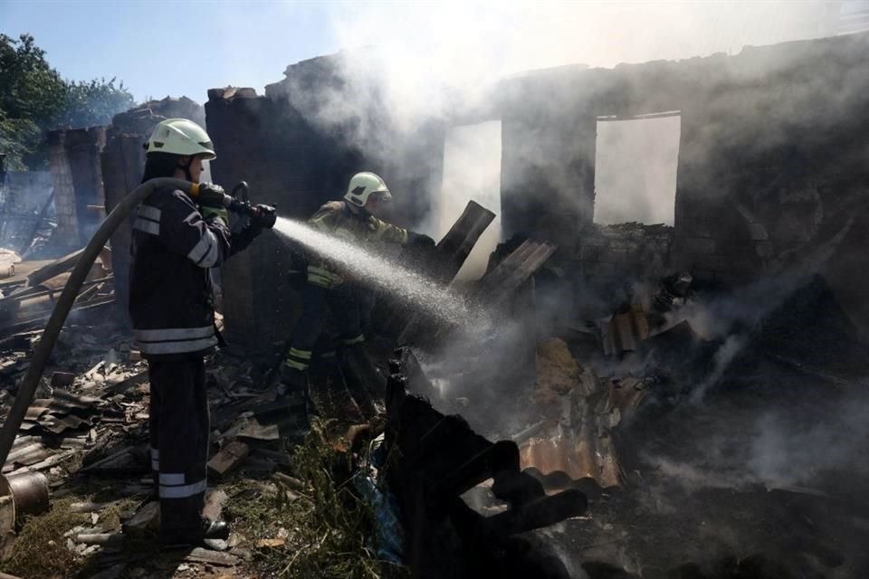 Bomberos ucranianos trabajan en Bakhmut, donde también fueron bombardeadas viviendas por misiles rusos.