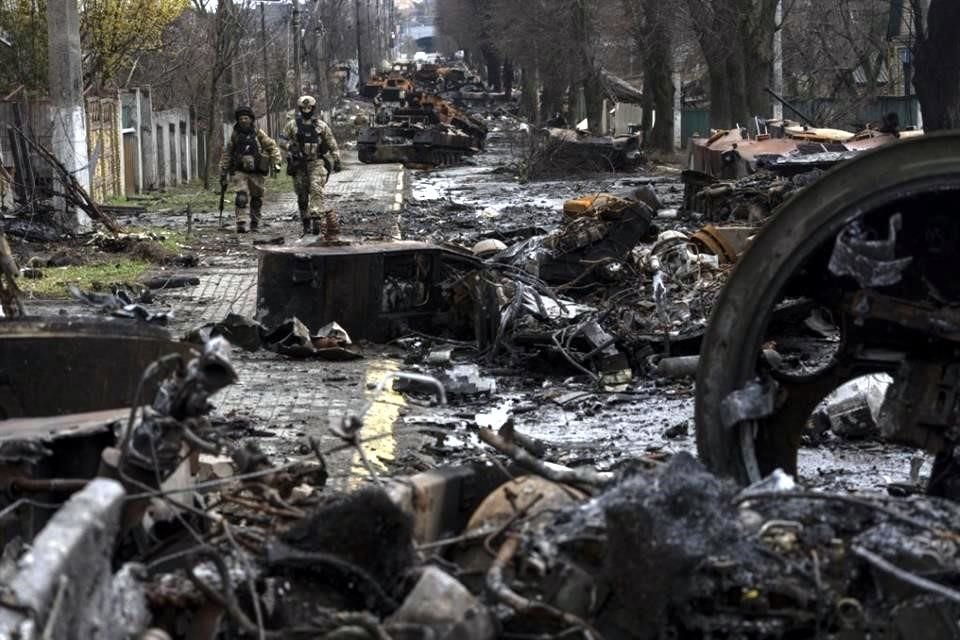 Soldados caminan en medio de tanques rusos destruidos en las afueras de Kiev, en abril pasado.