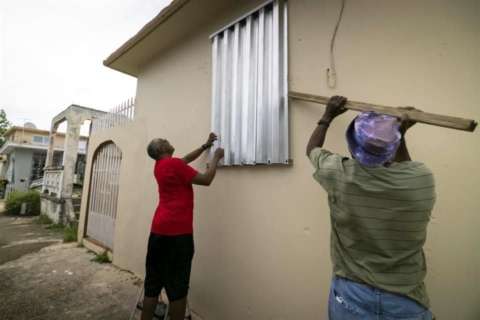 Residentes de Loiza, Puerto Rico, bloquean las ventanas de sus casas a la espera de la llegada del huracán 'Fiona'.