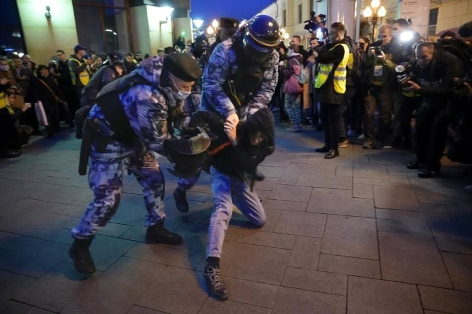 Policías antimotines arrestan personas durante una manifestación en Moscú este miércoles.