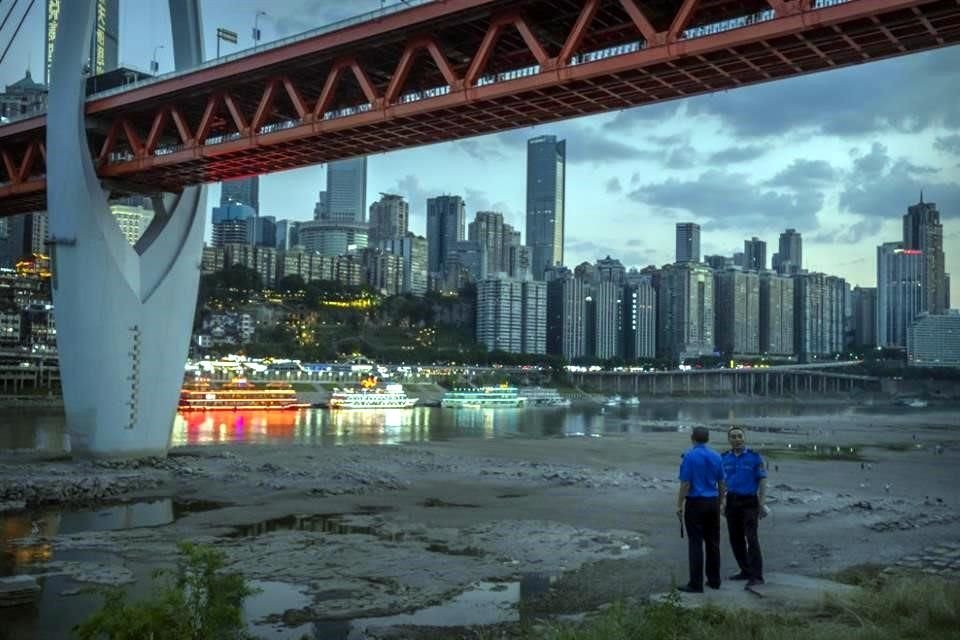 Oficiales de seguridad miran el río seco de Jialing River, en Chongqing, China.