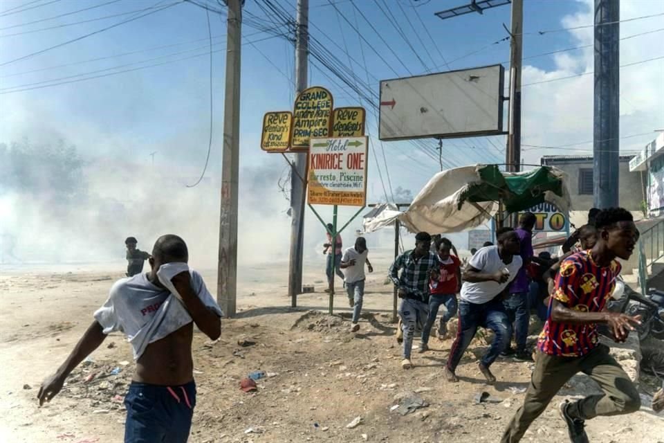 Manifestantes huyen de los gases lacrimógenos lanzados por la policía en Puerto Príncipe.