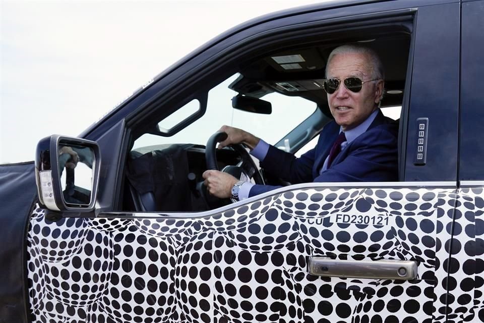 El Presidente Joe Biden se detiene para hablar co los medios, mientras conduce la Ford F-150 Lightning.