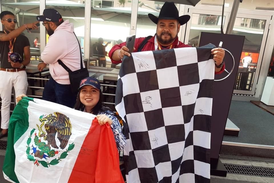 María Camila y su padre presumen las banderas firmadas por varios pilotos en el Autódromo Hermanos Rodríguez.