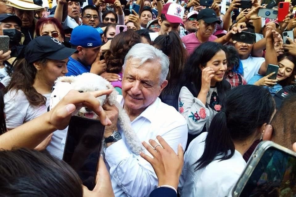 A su paso, los manifestantes le entregan gorras, documentos, le piden una foto o hasta que cargue a un perro.