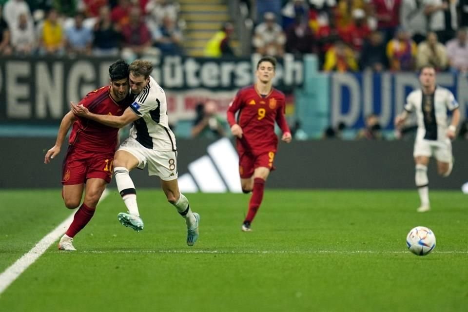 Curiosa imagen de Marco Asensio con Leon Gorentzka en carrera buscando el balón.