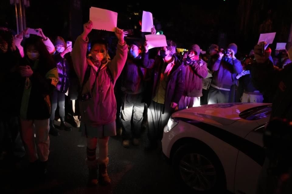 Manifestantes muestran hojas en blanco durante una protesta en Beijing en contra de la censura y la política de Covid Cero.