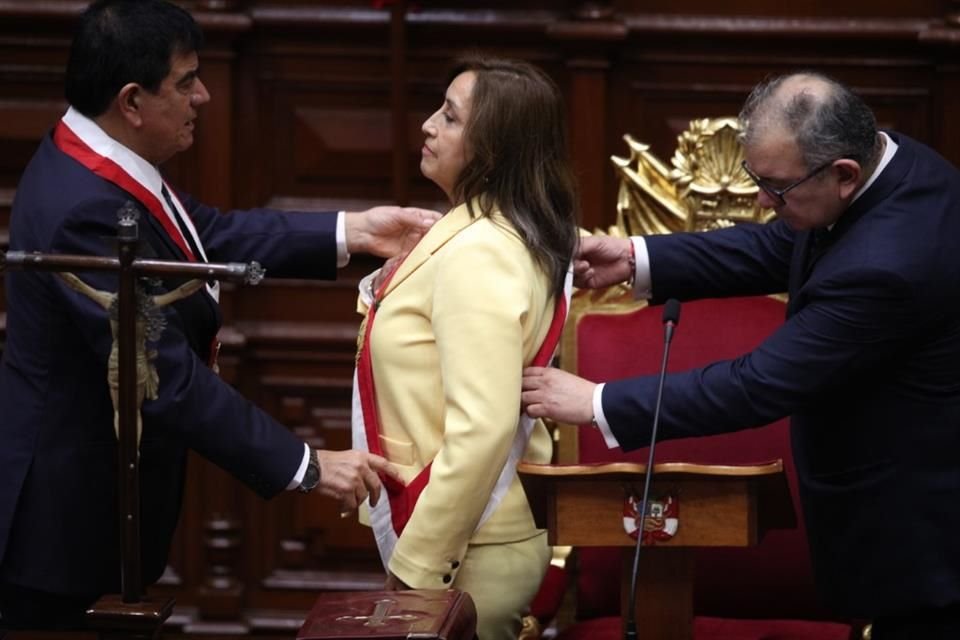 El presidente del Congreso de Perú, José Williams, y el senador José Cevasco colocan la banda presidencial a la Vicepresidenta Dina Boluarte en su toma de posesión como nueva Presidenta.