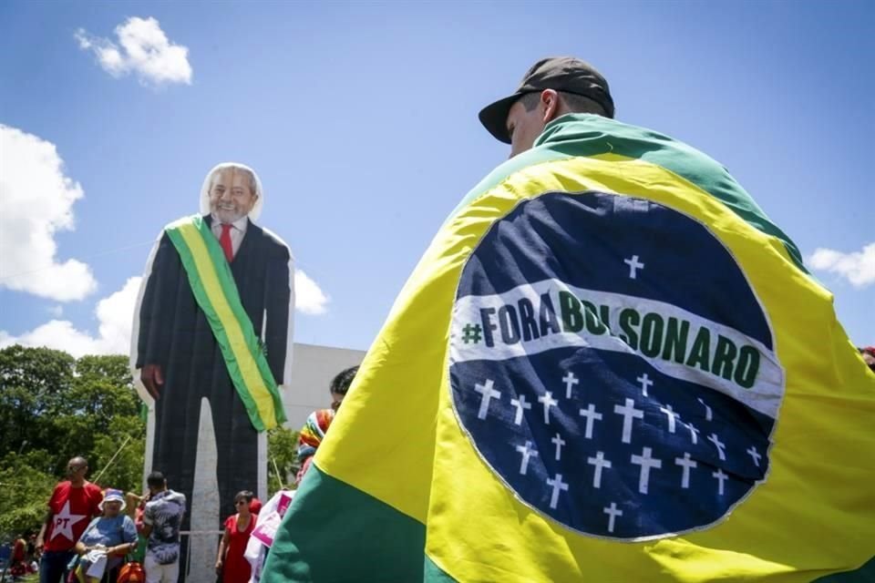 Un hombre lleva una bandera que dice 'Fuera Bolsonaro' antes de la asunción de Lula da Silva.