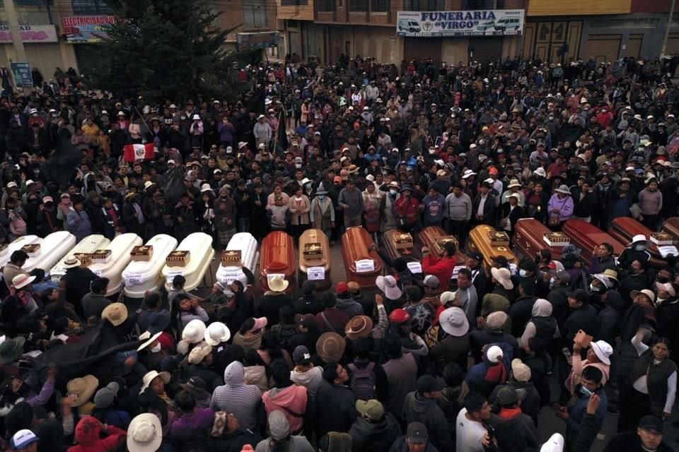 Residentes rodean los féretros durante una vigilia por los fallecidos durante los disturbios en Juliaca, Perú.