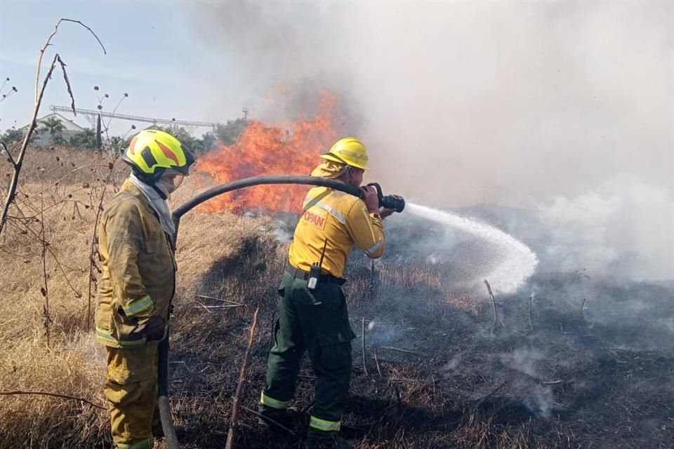 Integrantes de la Coordinación municipal de Protección Civil y Bomberos de Zapopan combaten un incendio registrado junto a un parque industrial en la zona de la Carretera a Nogales.