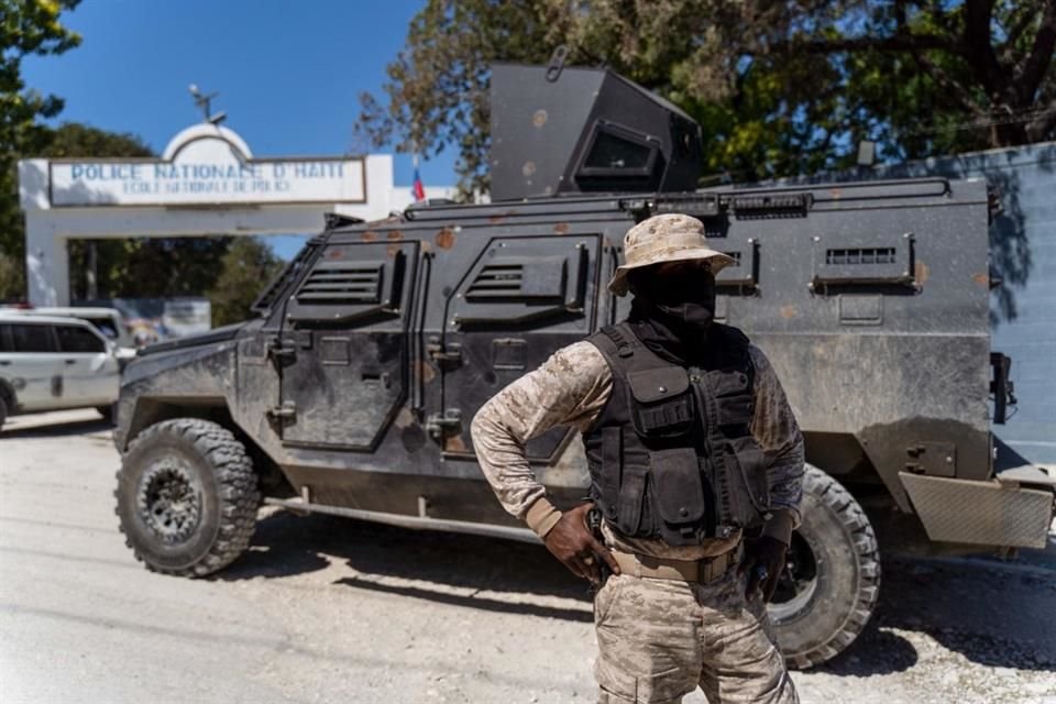 Policías haitianos patrullan afuera de la Escuela Nacional de Policías, donde se lleva a cabo el funeral de tres de sus compañeros.