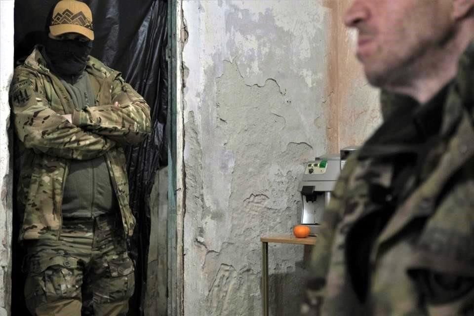 Un militar ucraniano (izq.) observa un miembro del grupo paramilitar ruso Wagner en la sala de interrogatorios después de ser capturado por soldados ucranianos cerca de Bakhmut.