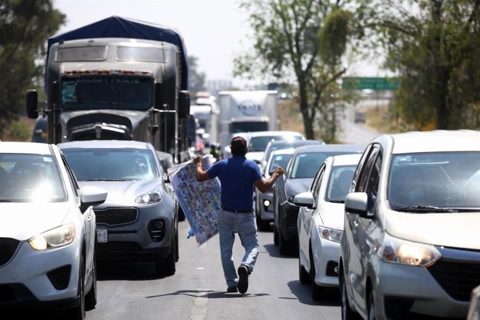 Los vendedores ambulantes aprovechan que por momentos el tráfico va a vuelta de rueda, para ofrecer sus productos.