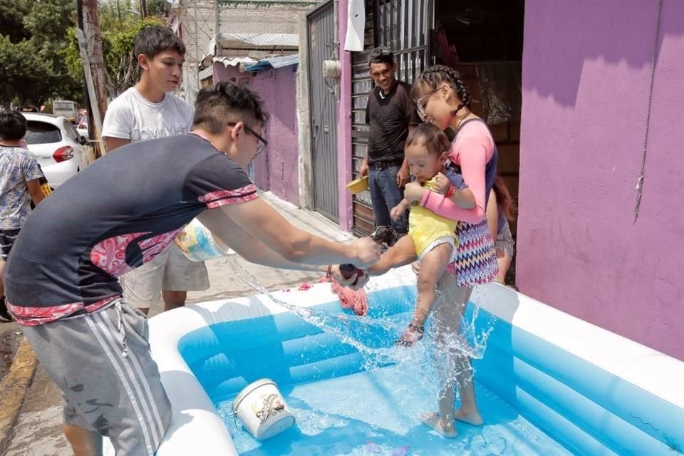 Una familia pone alberca afuera de su casa y aprovecha para mojarse entre vecinos en la colonia San Andrés Tetepilco